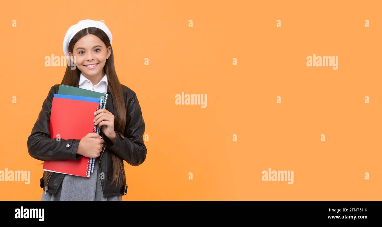 Glücklich Schulalter Mädchen Kind halten Bücher September 1 orange Hintergrund copy space, zurück zur Schule Stockfoto