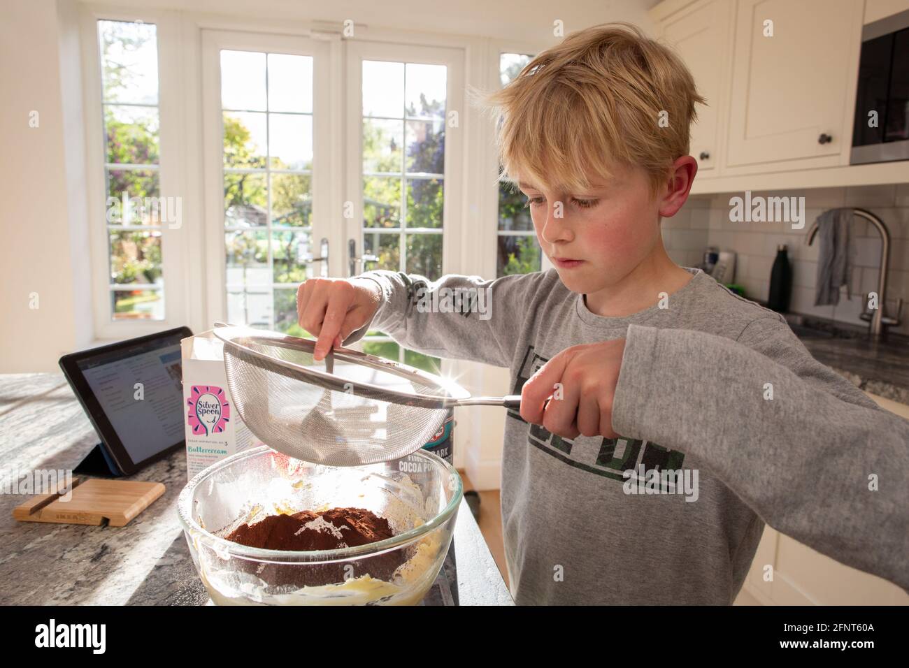 10-jähriger Junge bereitet Zutaten für den Schokoladenkuchen zu Hause, England, Großbritannien, zu Stockfoto