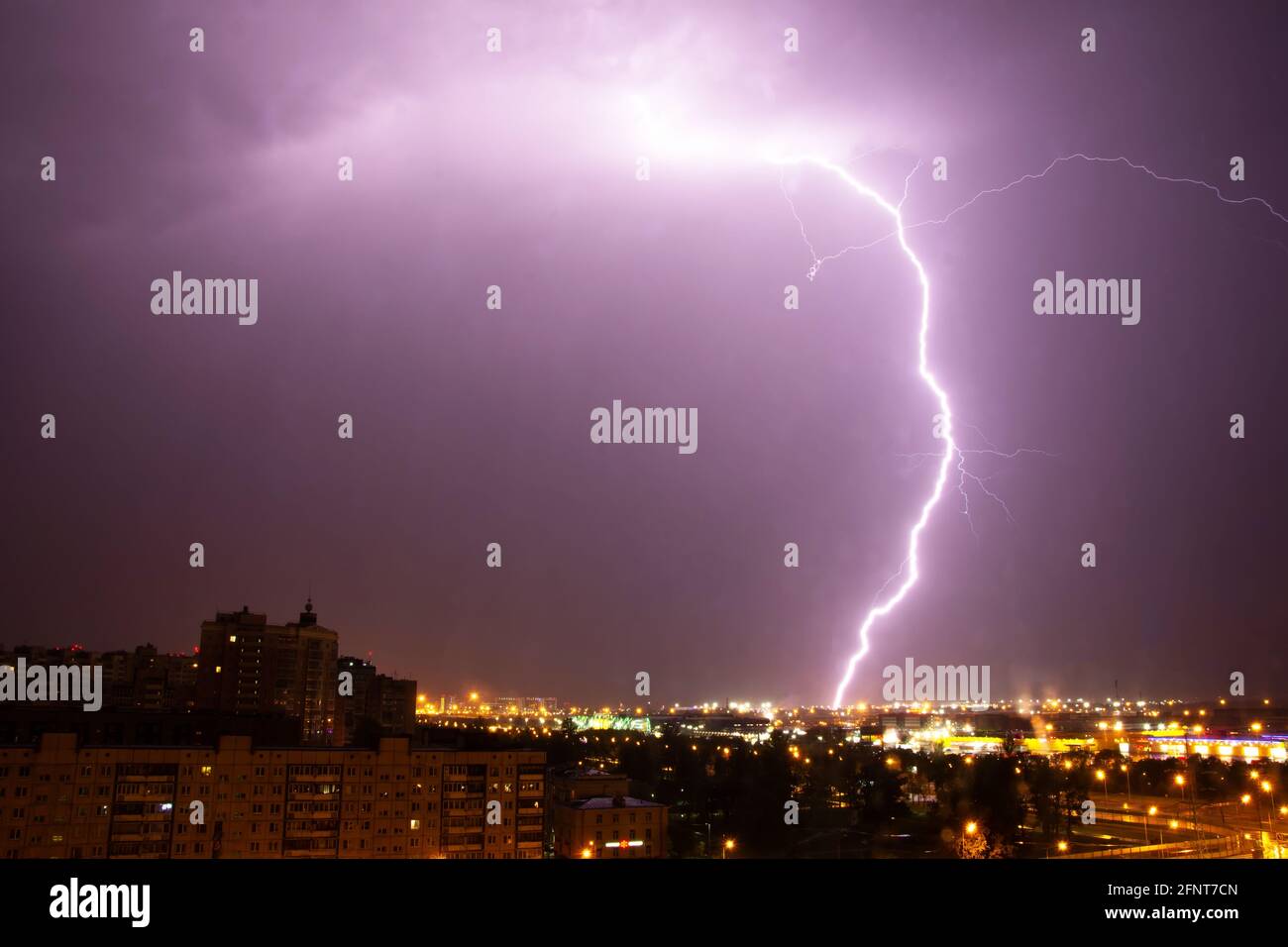 Nachts trifft ein Blitz in der Stadt auf den Boden Stockfoto