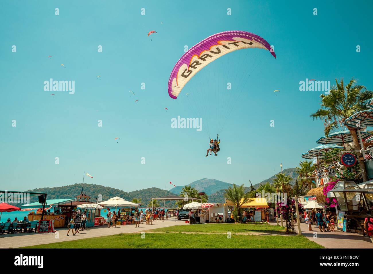 Oludeniz, Türkei - 13. August 2017: Gleitschirme landen auf der Promenade in Oludeniz, Türkei Stockfoto