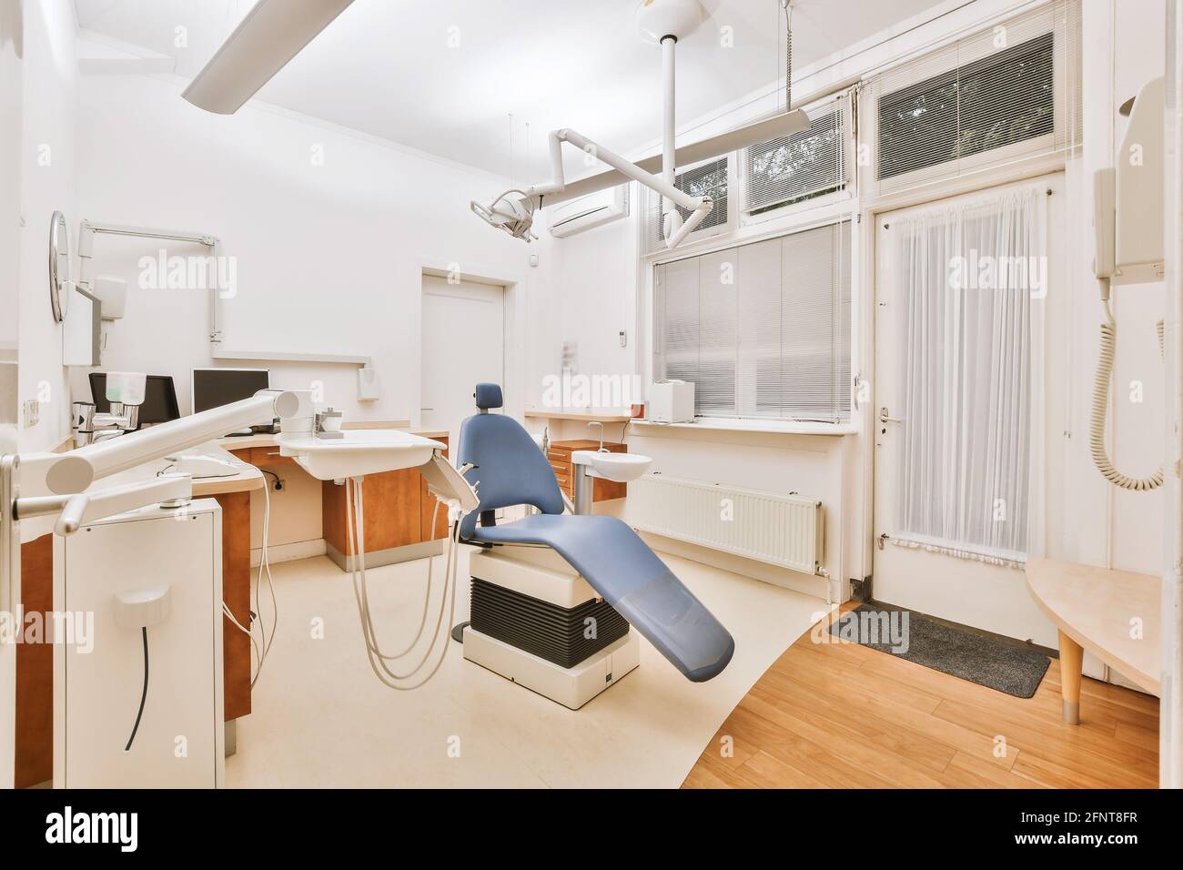 Schreibtisch und Stuhl in der Nähe von professionellen zahnmedizinischen Geräten im Büro platziert Der modernen Klinik Stockfoto