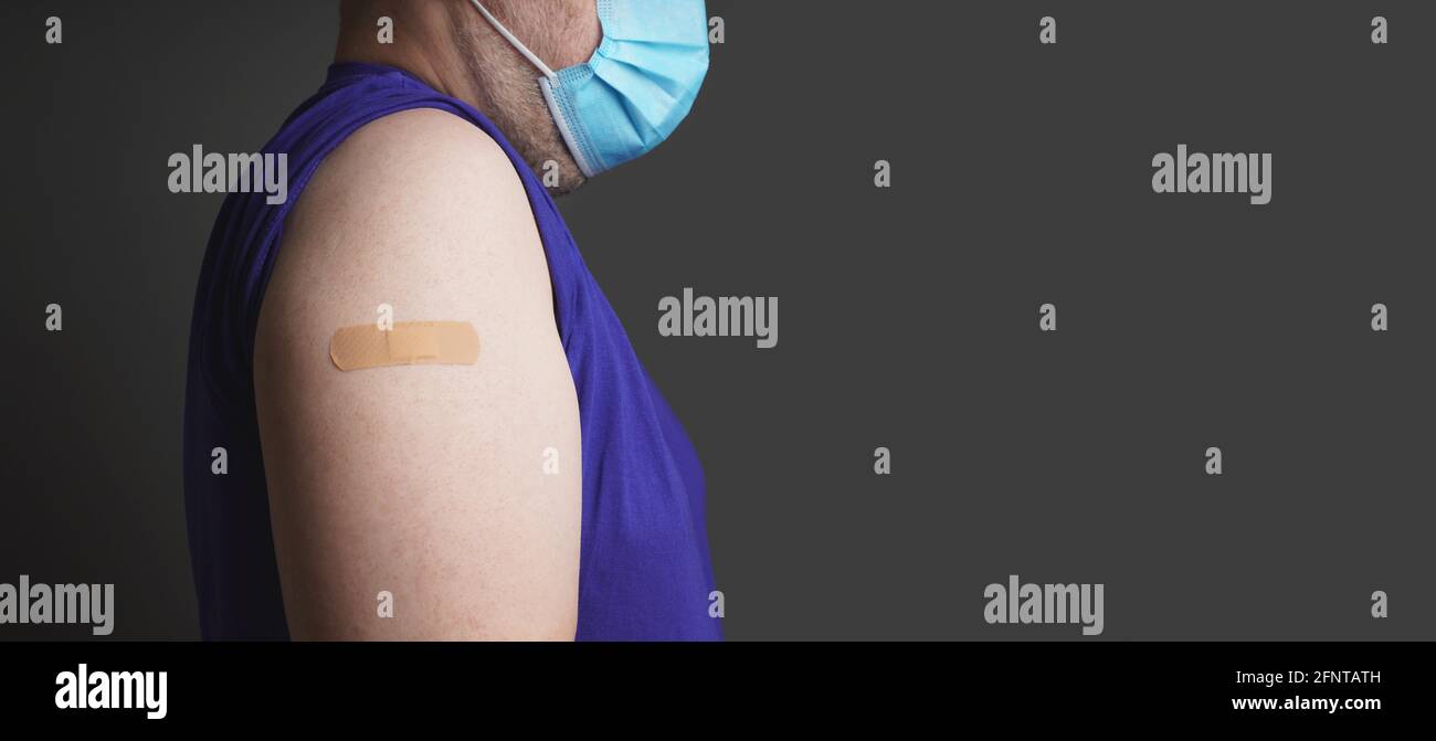 Nicht erkennbarer älterer Mensch mit Gips am Arm und medizinischer Versorgung Gesichtsmaske nach der Corona-Covid-19-Impfung Stockfoto