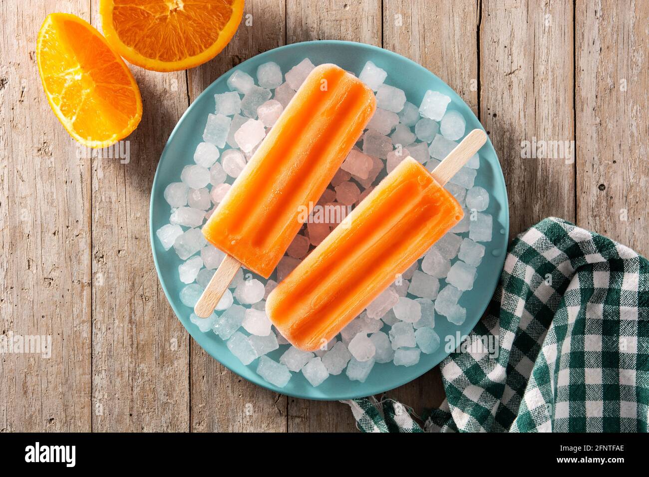 Orangefarbene Eiszapfen auf einem Holztisch Stockfoto