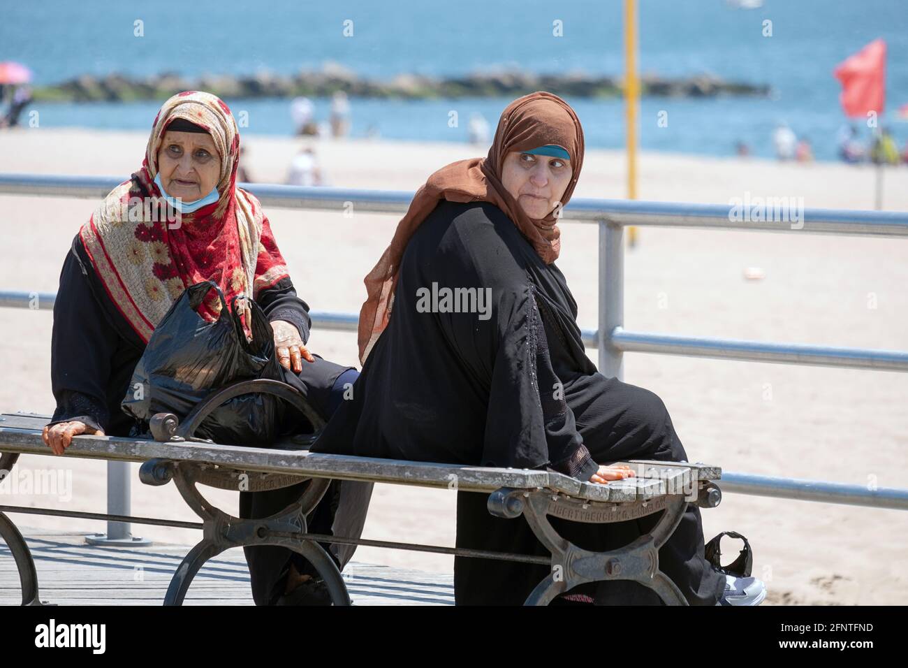 Schlepptau Ältere muslimische Frauen in Hijabs schlagen ähnliche Posen auf der Promenade in Coney Island, Brooklyn, New York City. Stockfoto