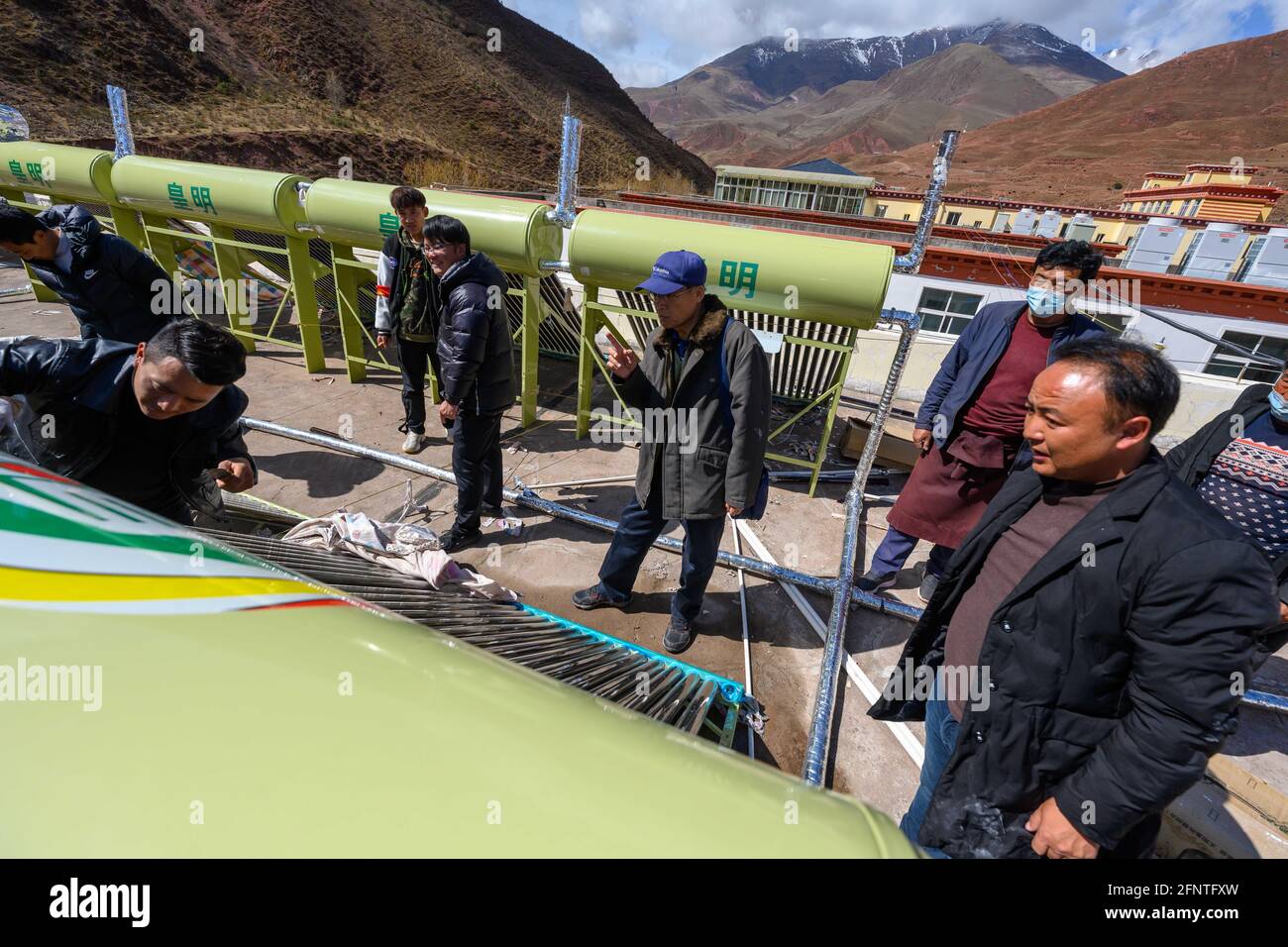 (210519) -- PEKING, 19. Mai 2021 (Xinhua) -- Li Chunmin (C) überwacht die Installation von Solarwarmwasserbereitern auf dem Dach des Speisesaals der Grundschule der Gemeinde Jigdoi in der Gemeinde Jigdoi, Bezirk Riwoqe von Qamdo, südwestlich der Autonomen Region Tibet, 3. Mai 2021. Im China Photo Archive von Xinhua befindet sich ein Foto eines Geldauftrags, der vor 20 Jahren von einem Xinhua-Reporter angenommen wurde - die erste Überweisung, die vom Qinghai-Tibet Railway Construction Headquarters erhalten wurde. Der Geldbefehl wurde nicht unterzeichnet, da der Übermittlungsgeber nur „Cadre Sent to Support Tibet in 1979“ darauf setzte. Zwanzig Jahre später, Xinhua repo Stockfoto