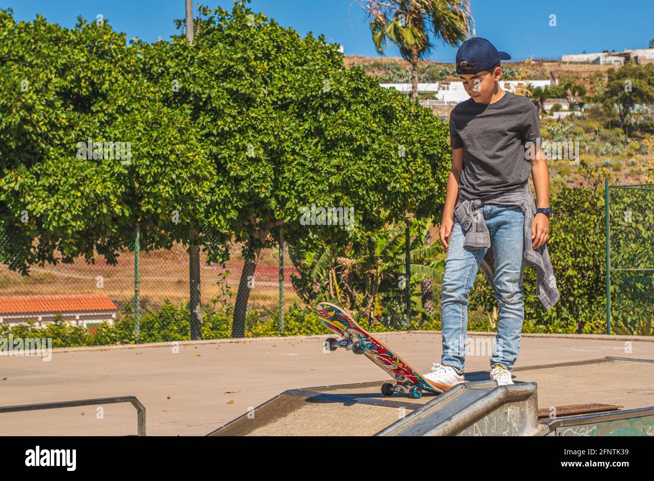 Kaukasischer Preteen-Skater, kurz vor einem Skateboard-Hindernis mit seinem Skateboard. Stockfoto