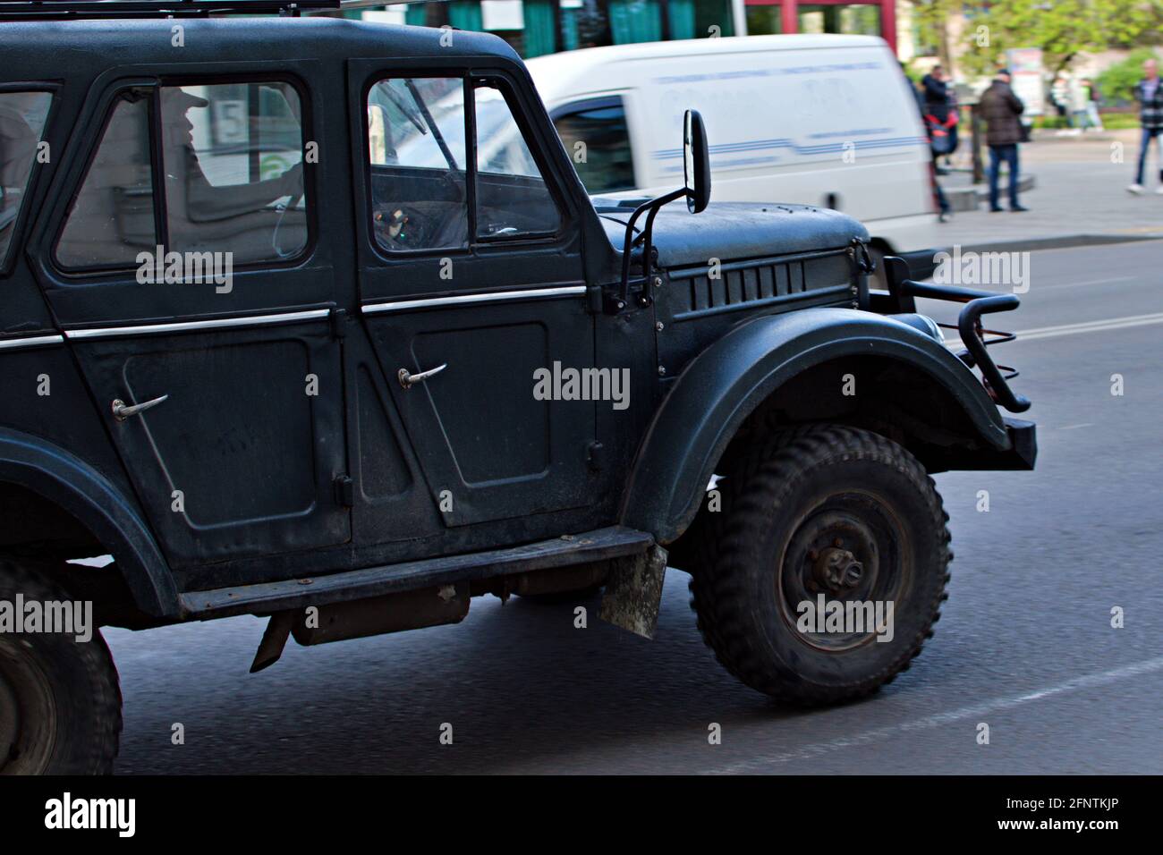 Altes SUV auf einer Stadtstraße. Räder in unscharfer Bewegung Stockfoto