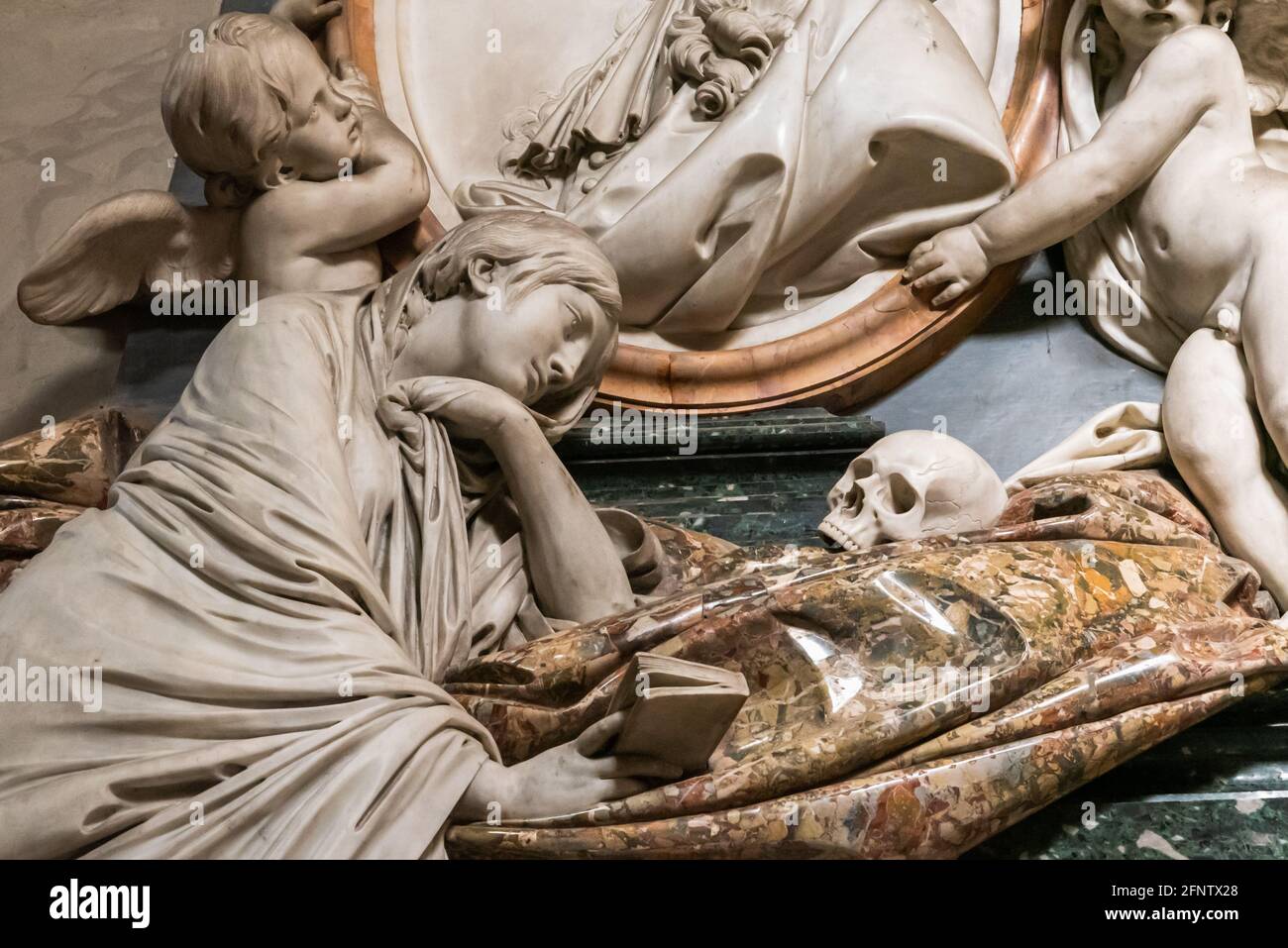 Detail der alten Grabdekoration in Marmor zeigt die Skulptur Einer Frau, die sich über einen menschlichen Schädel lehnte und umzingelt war Von Engeln Stockfoto