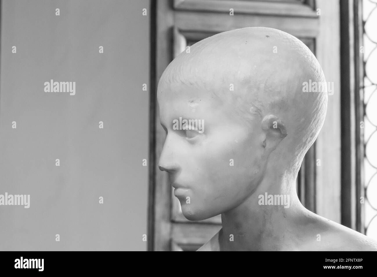 Schwarzweiß-Foto, das in Nahaufnahme den Kopf zeigt Alte römische Skulptur eines jungen Jungen Stockfoto