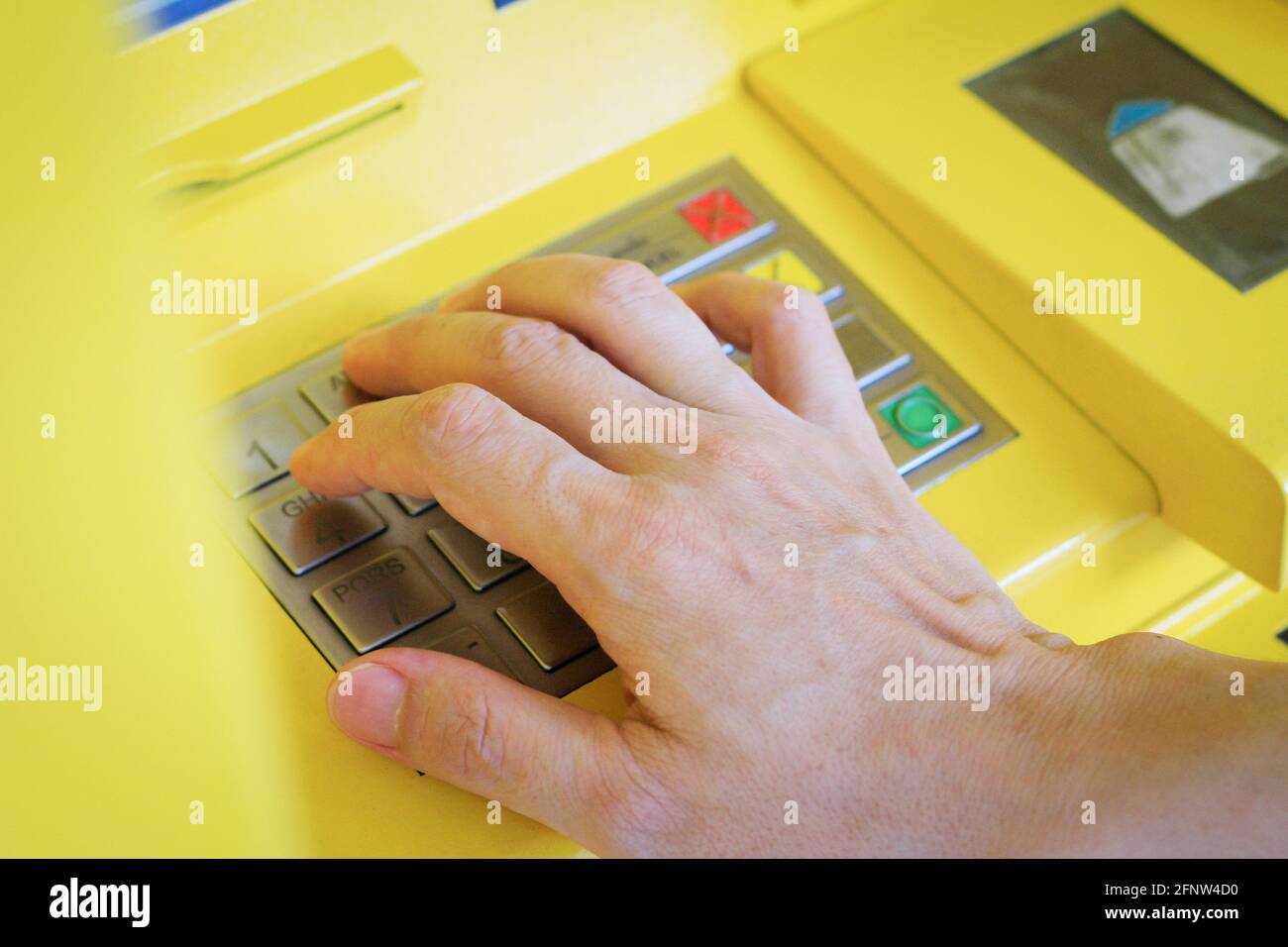 Mann drückt auf dem Geldautomaten die Passwortnummer Stockfoto