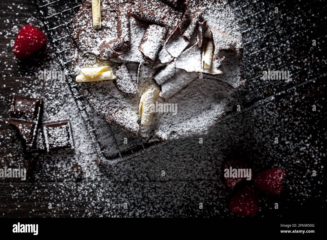 Schokoladenkuchen und Himbeeren mit Puderzucker überzogen Stockfoto