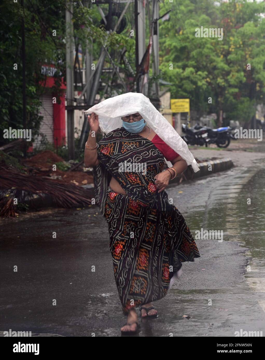 Prayagraj, Uttar Pradesh, Indien. Mai 2021. Prayagraj: Eine Frau trägt Plastikfolie, um am Mittwoch, den 19. Mai 2021, vor einer Regendusche in Prayagraj sicher zu sein. Quelle: Prabhat Kumar Verma/ZUMA Wire/Alamy Live News Stockfoto