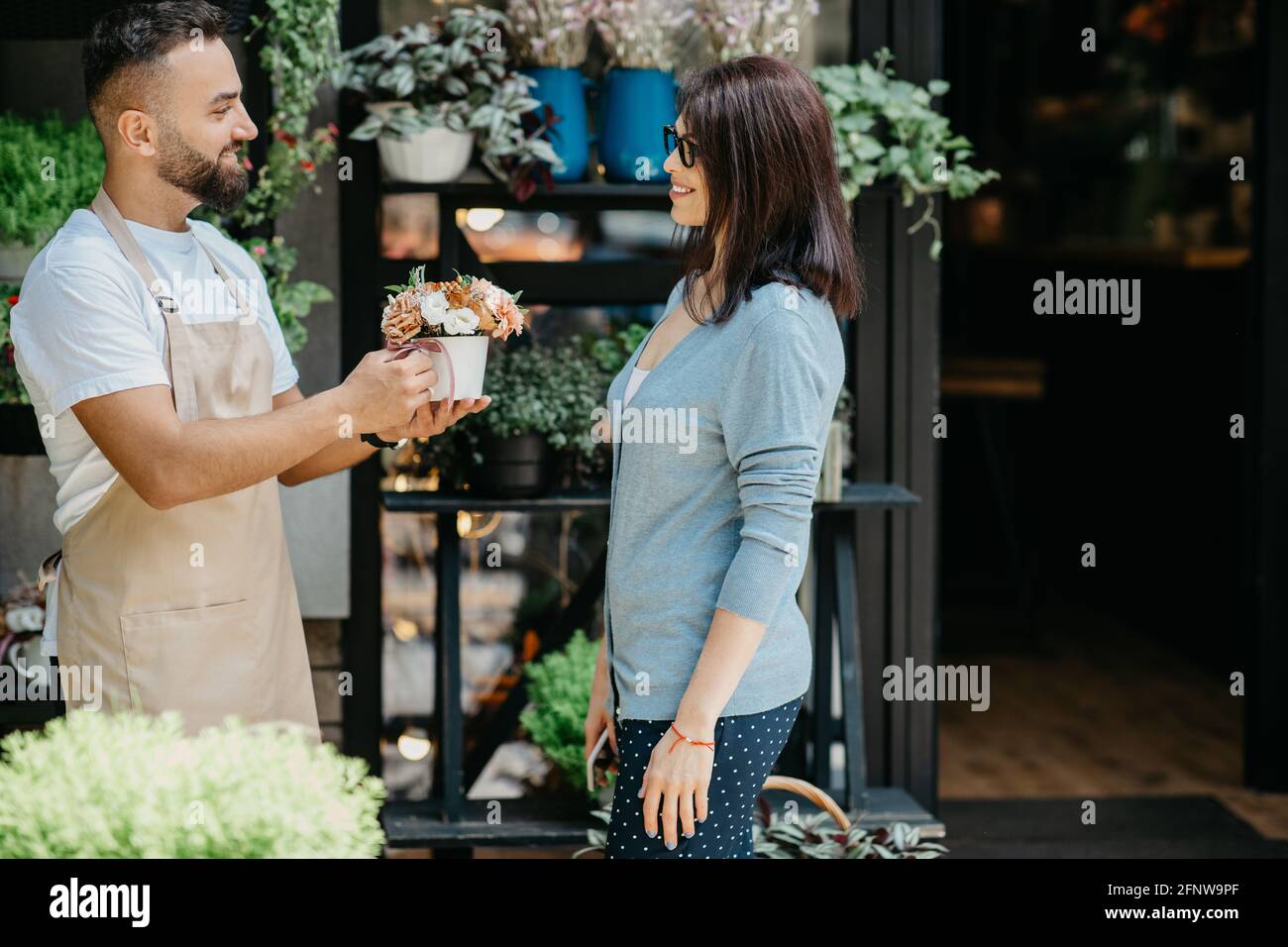 Verkauf von Blumen im Geschäft, ausgezeichneter Kundenservice und Arbeit im Freien Stockfoto