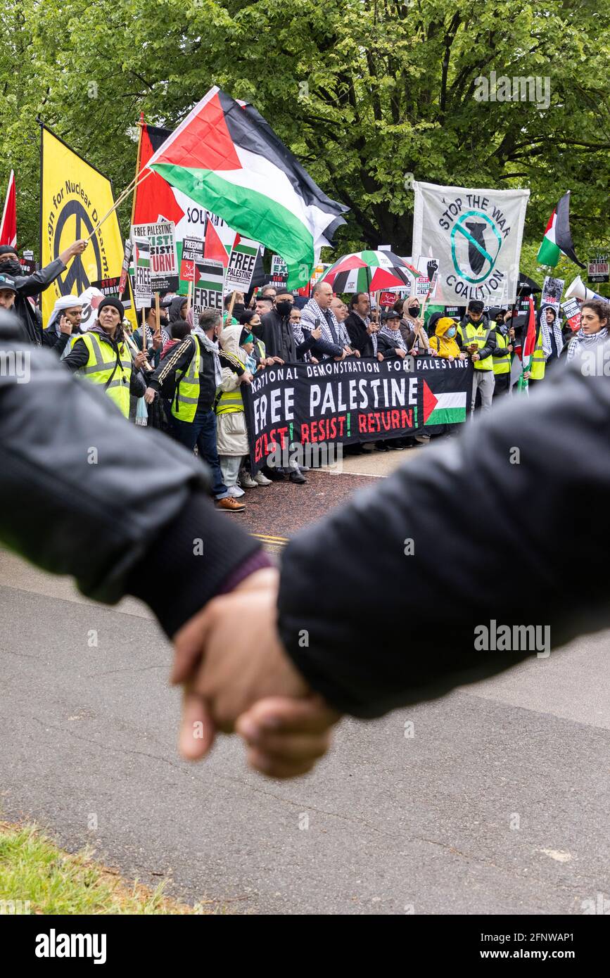 Demonstranten halten die Hände mit Menschenmenge hinter sich, Solidaritätssprotest „Freies Palästina“, London, 15. Mai 2021 Stockfoto