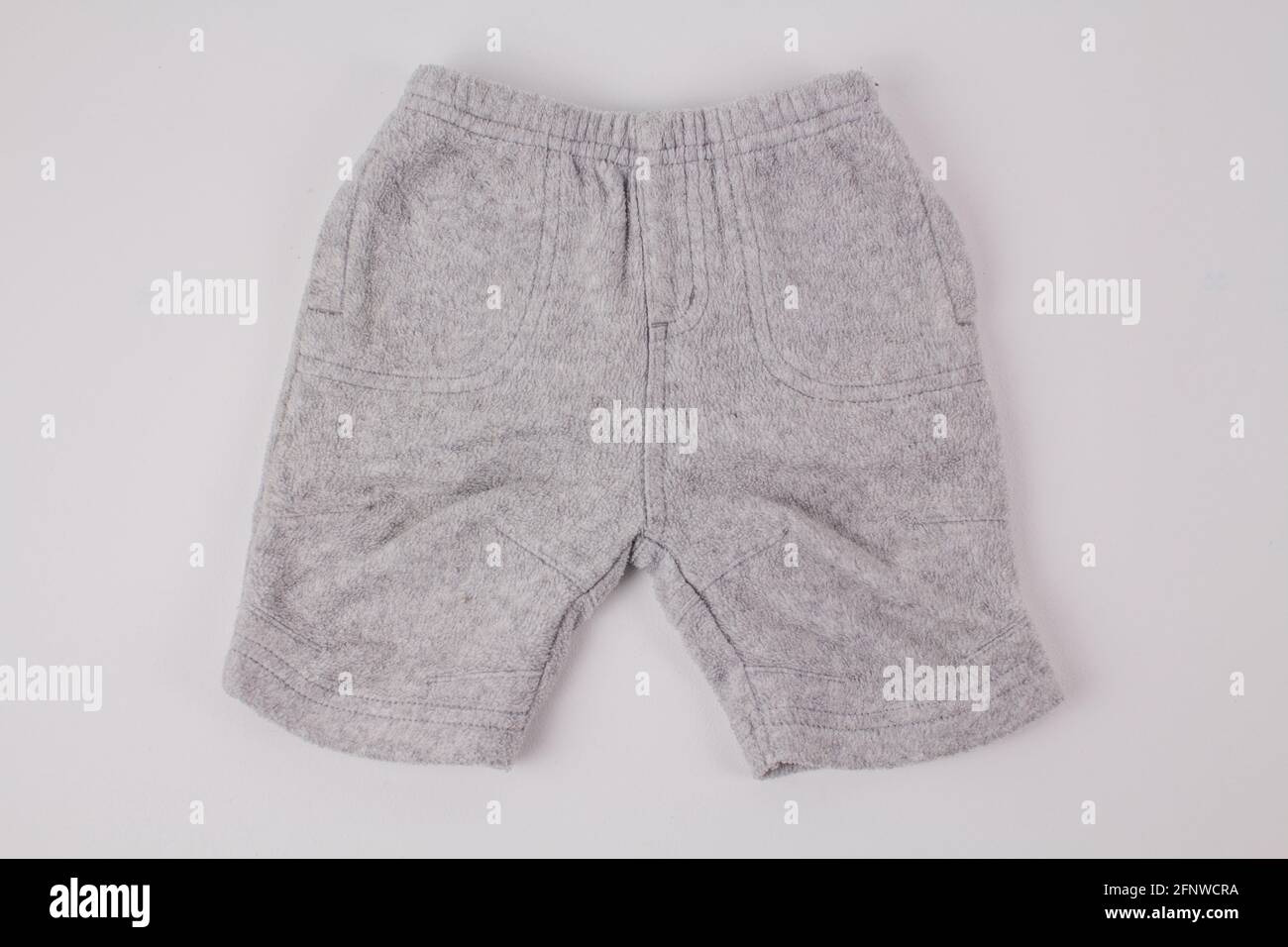 Eine graue Kinderhose auf weißem Hintergrund Stockfoto