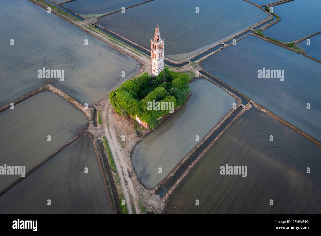 Sonnenuntergang über den Reisfeldern und verlassene Kirche von Sant'Antonio. Casaleggio di Novara, Novara, Piemont, Italien. Stockfoto