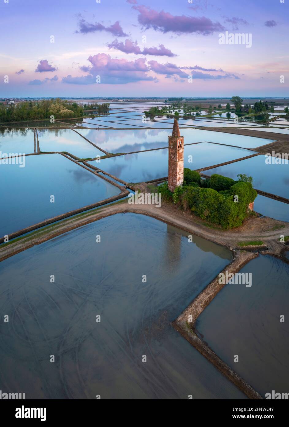 Sonnenuntergang über den Reisfeldern und verlassene Kirche von Sant'Antonio. Casaleggio di Novara, Novara, Piemont, Italien. Stockfoto