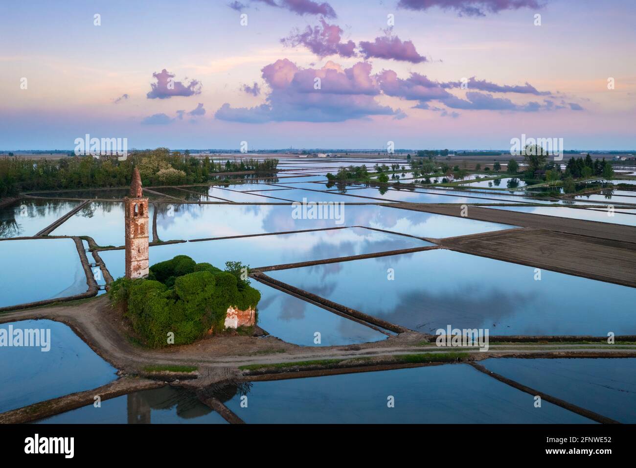 Sonnenuntergang über den Reisfeldern und verlassene Kirche von Sant'Antonio. Casaleggio di Novara, Novara, Piemont, Italien. Stockfoto