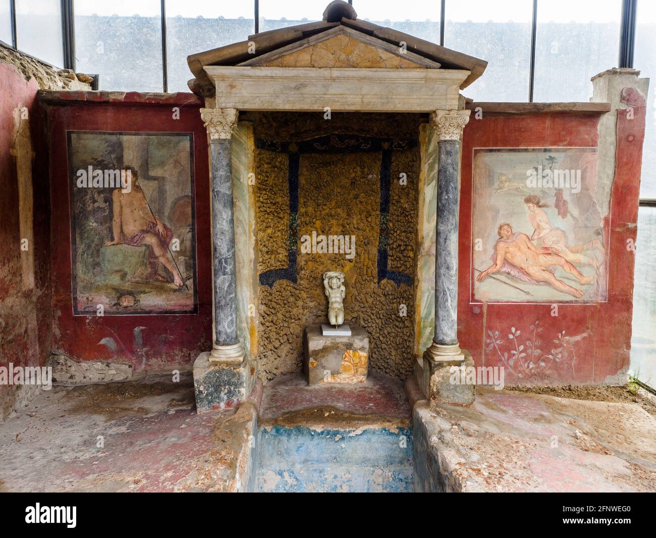 Biclinium (Esszimmer) - Haus des Octavius Quartio - archäologische Stätte von Pompeji, Italien zentraler Brunnen, der aus einer Struktur im Tempelstil stammt, die von zwei korinthischen Säulen getragen wird. Fresken, eine Seite des Brunnens. Die Motive der beiden Fresken - Narzisse am Frühling (links) und Pyramus, der Selbstmord begeht (rechts) - haben ein gemeinsames Thema: Tod durch Leidenschaft Stockfoto