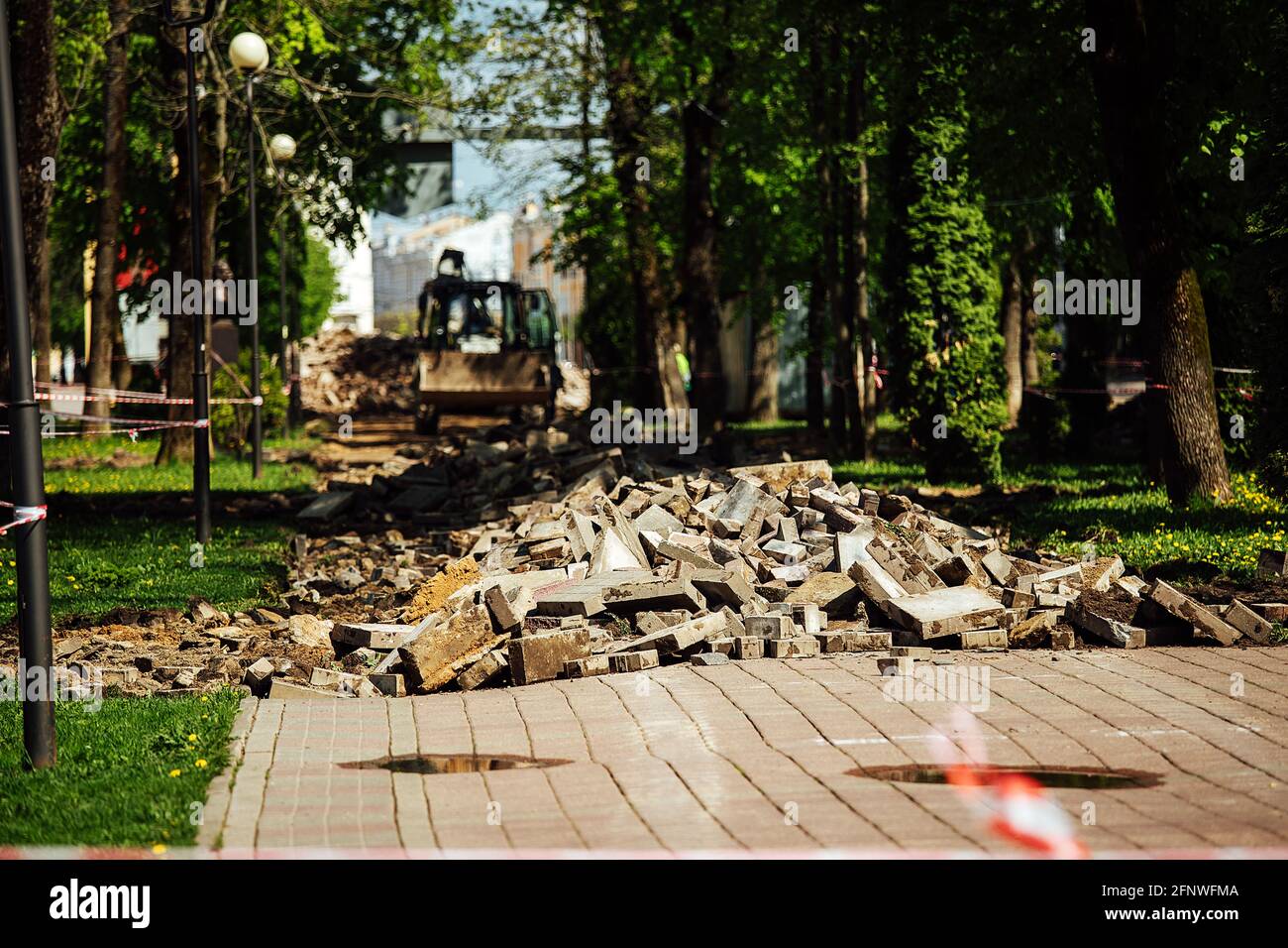 Ein Warnband verbietet den Durchgang. Absperrband um den gefährlichen Ort. Reparaturarbeiten an der Stelle des Asphaltausfalls nach der Katastrophe. Absperrband Stockfoto