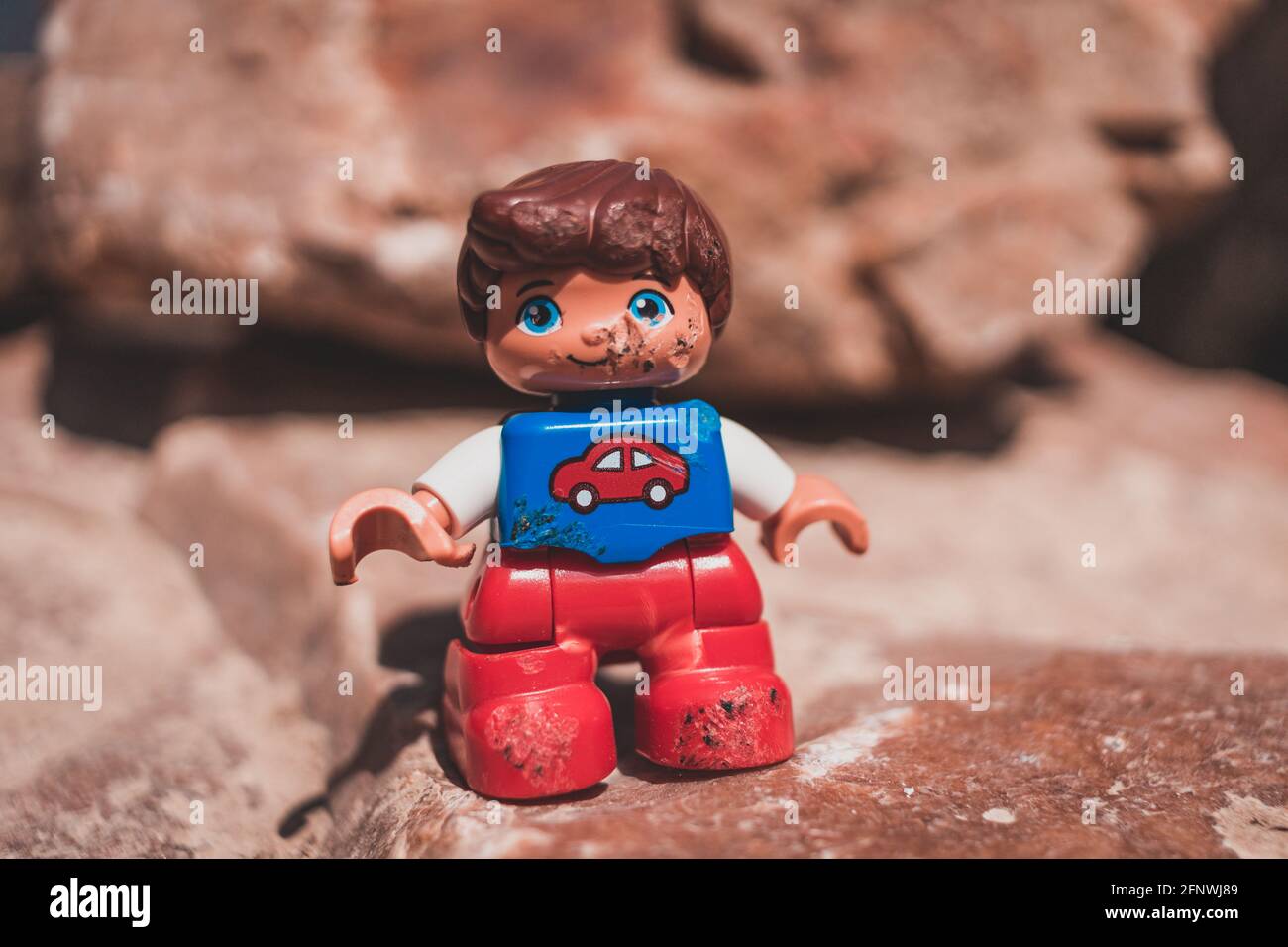 Beschädigte Spielzeugjunge Figur in rot und blau mit Auto auf der Brust anmelden Stockfoto