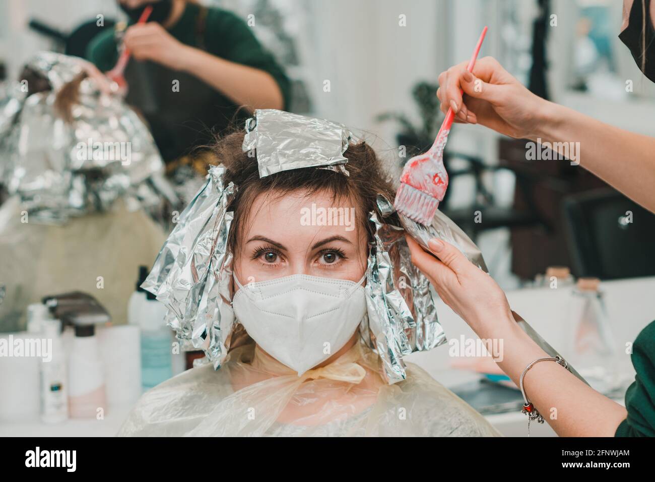 Frau färbt ihre Haare in einem Friseurladen, den Prozess des Färbens ihr Haar mit Folie. Neu Stockfoto