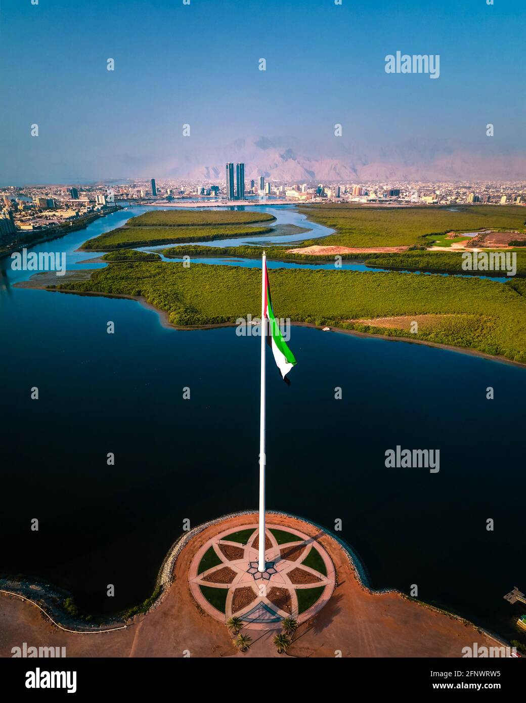Der nationale Fahnenmast der Vereinigten Arabischen Emirate und Ras al Khaimah emiraten ein Das Wahrzeichen und die Skyline der Skyline der nördlichen Vereinigten Arabischen Emirate Blick über die Mangroven an Stockfoto