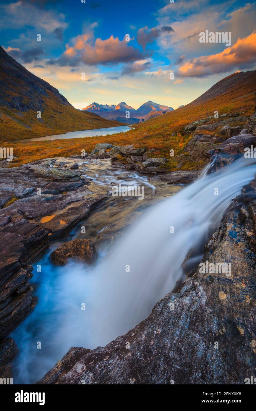 Wasserfall, Abendlicht und Alpenglow in der Berglandschaft in Vengedalen, Rauma kommune, Møre Og Romsdal, Norwegen, Skandinavien. Stockfoto