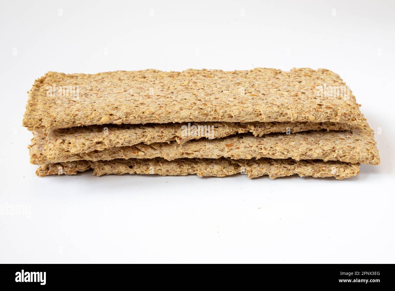 Haufen hellbrauner mehrkörniger Roggen-Knäckebrot isoliert auf weißem Hintergrund, Brotscheiben-Snacks, Seitenansicht Stockfoto