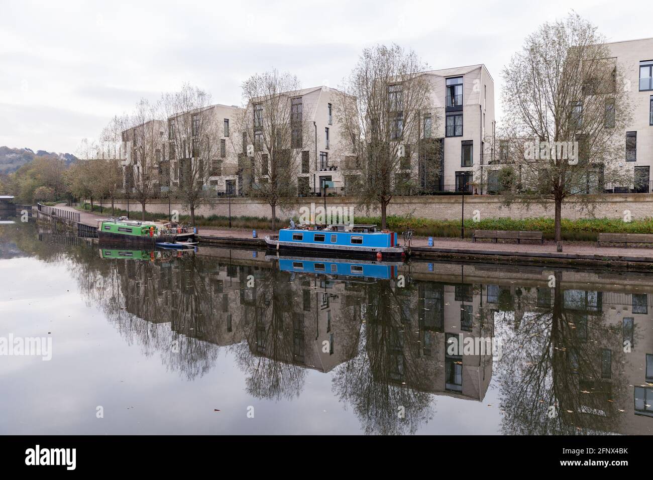 Bath, Großbritannien. Blick auf die Küste des Avon-Flusses mit festfahrenden kleinen Booten und modernen Wohnhäusern im Hintergrund Stockfoto