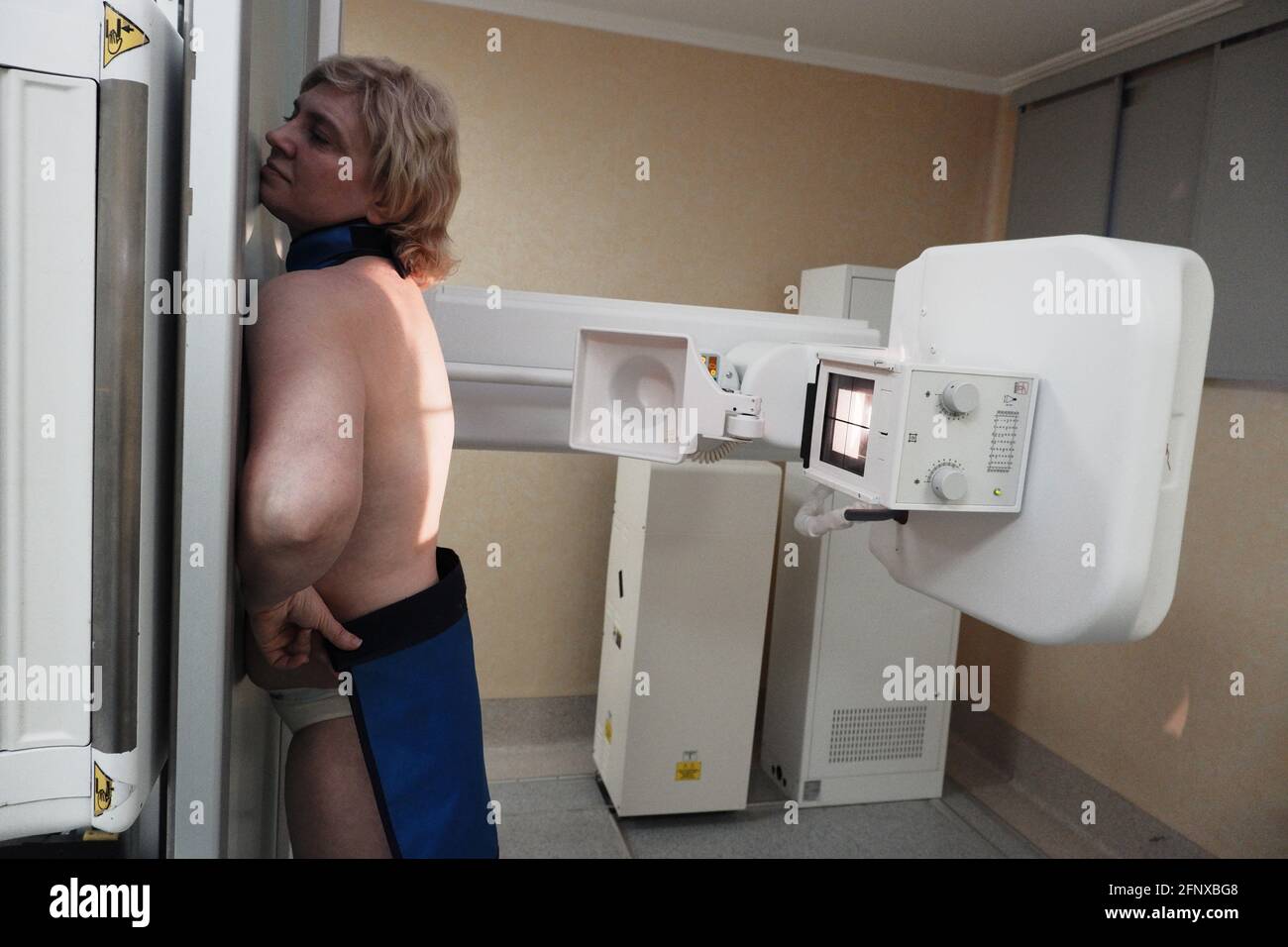 Eine Patientin in Unterwäsche auf einem Röntgentisch während Eine diagnostische Studie Stockfoto