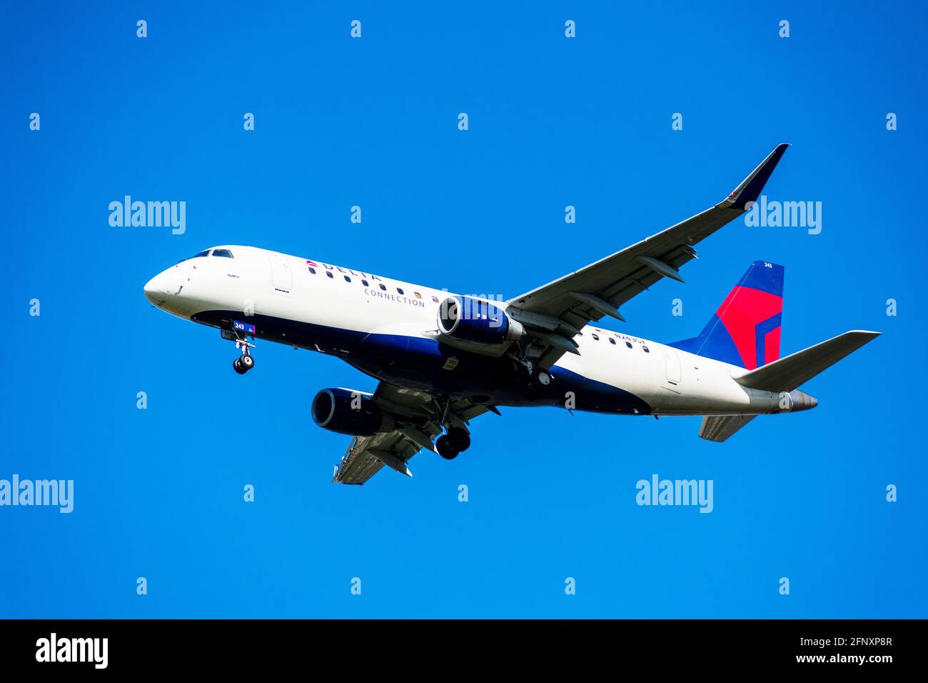 Delta Connection Embraer 175, ein Flugzeug von SkyWest Airlines, das mit eingesetztem Fahrwerk die Landung auf dem Flughafen vorbereitet. - San Jose, Kalifornien Stockfoto