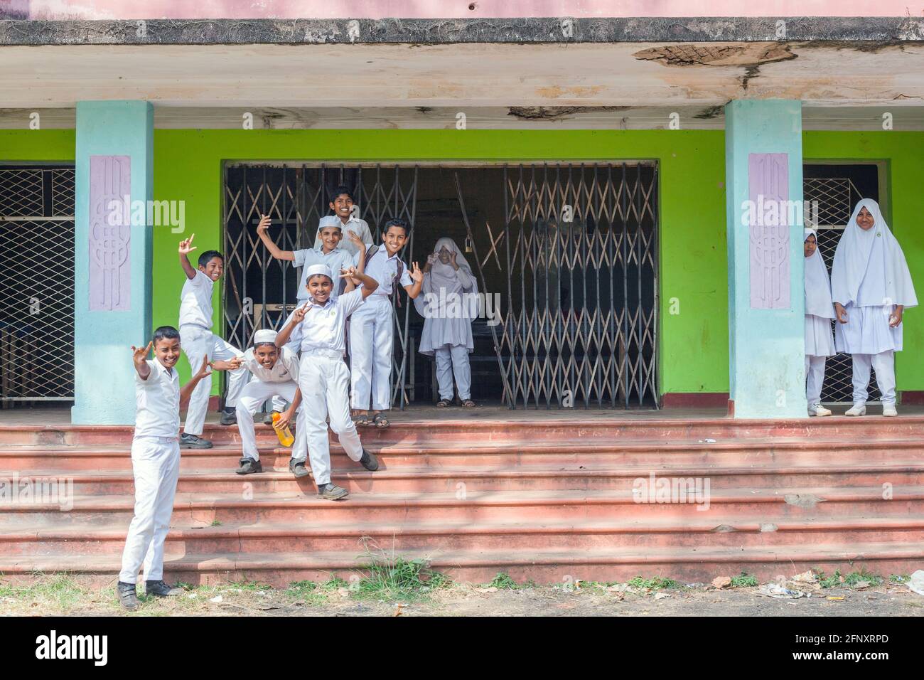 Muslimische Schülerinnen und Schüler winken und gestikulieren vor dem Schulgebäude in Anuradhapura, Sri Lanka, vor der Kamera Stockfoto