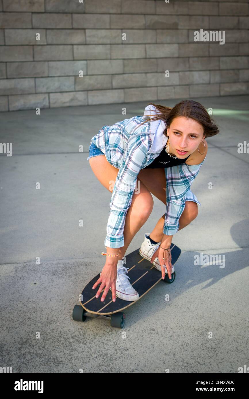 Junge Frau auf einem Skateboard in einer städtischen Innenstadt Stockfoto