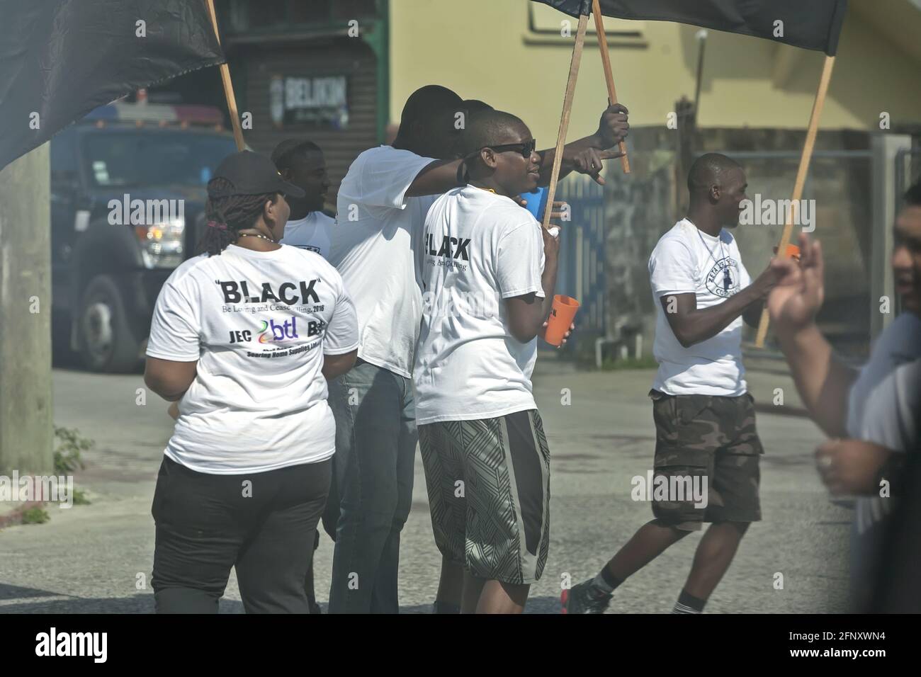 Belize City/Belize - 17. März 2016: Seid liebend und hört auf zu töten: Ein SCHWARZER Marsch gegen Verbrechen und Gewalt. Junge Menschen mit Fahnen auf der Straße. Stockfoto