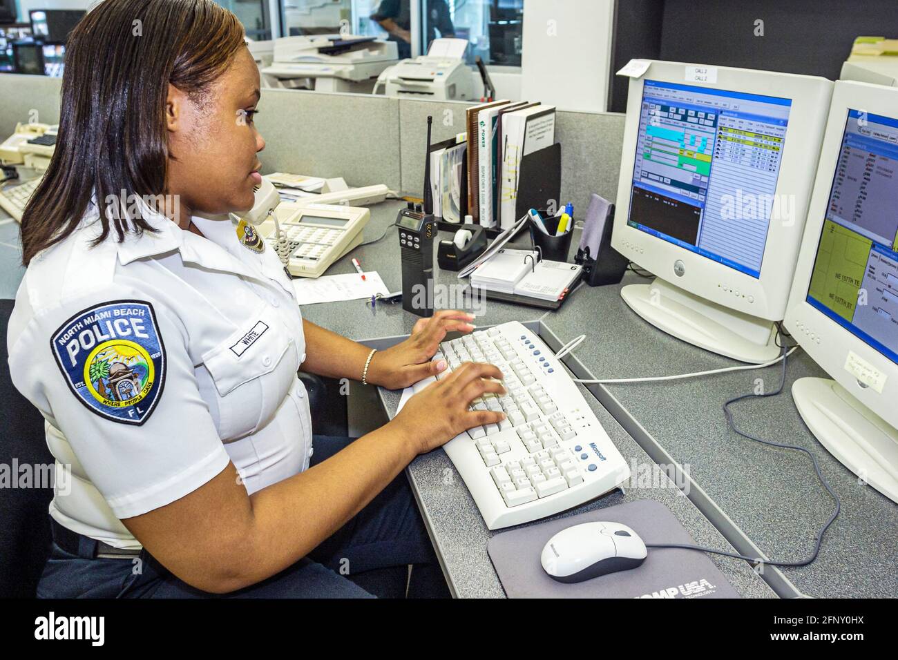 North Miami Beach Florida, Polizeibehörde, schwarze Frau weibliche Offizier Monitor Computer-Bildschirm Dispatcher Mitarbeiter arbeiten mit Tastatur Schreibtisch Stockfoto