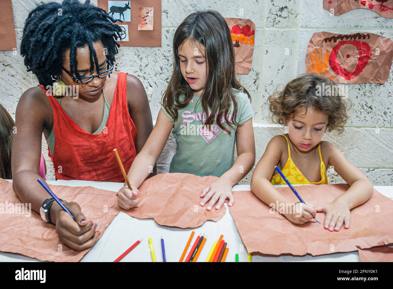 Miami Beach Florida, Bass Museum of Art Open House, Schwarze Frau Lehrerin hispanische Mädchen Mädchen Kinder, Zeichnen Kunst & Handwerk Projekt PR Stockfoto