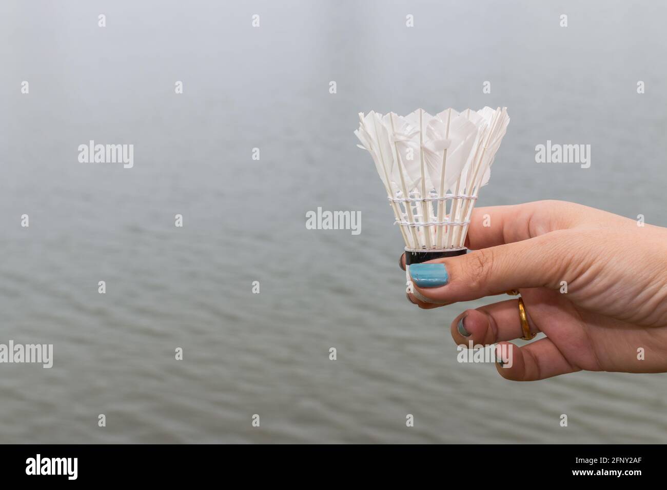 Weibliche Hand halten Federball, Badmintonball auf Wasser Hintergrund  Stockfotografie - Alamy