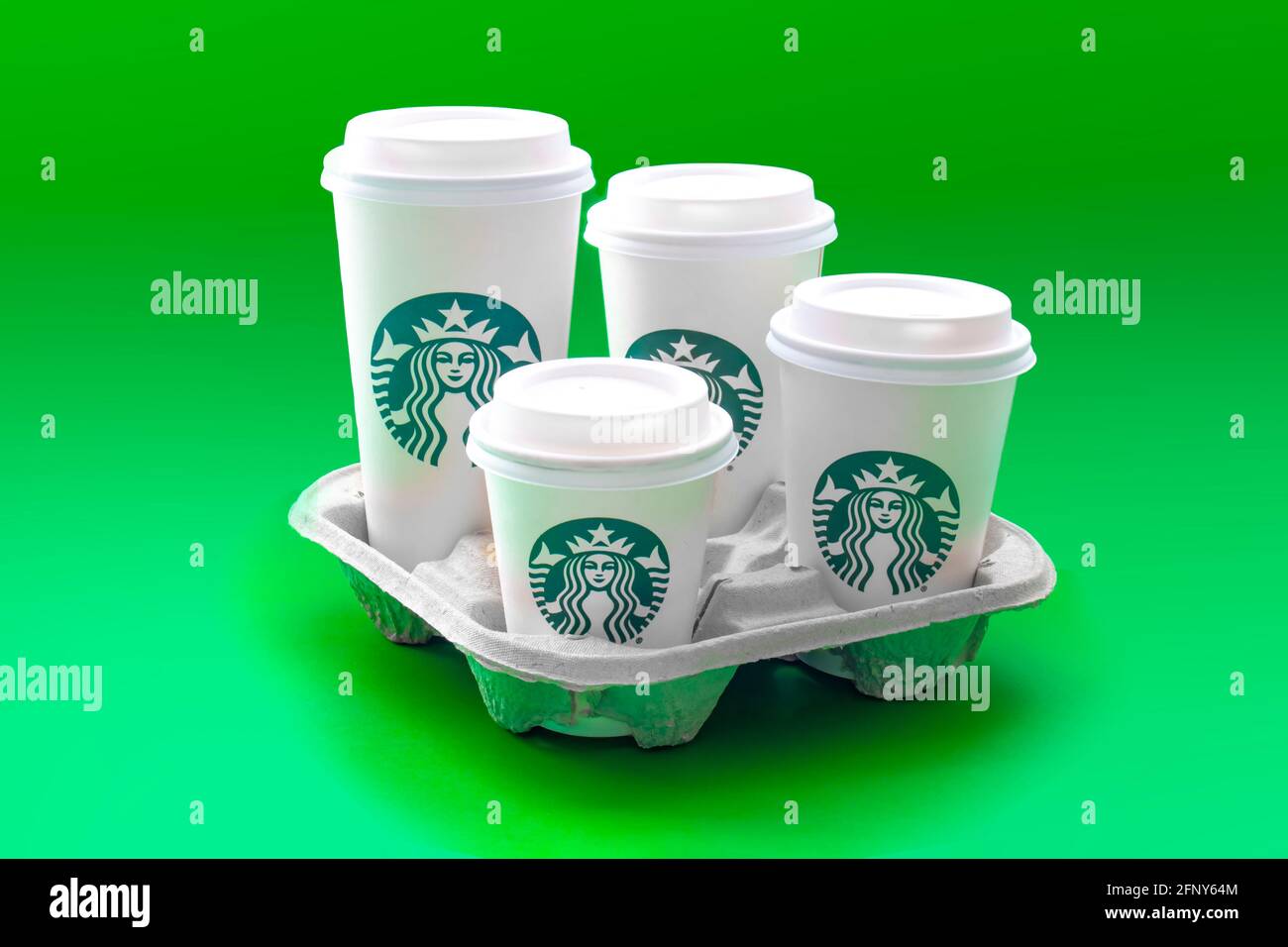 Calgary, Alberta, Kanada. 19.Mai 2021. Ein Trail mit Starbucks Kaffeetassen in vier verschiedenen Größen auf grünem Hintergrund. Stockfoto