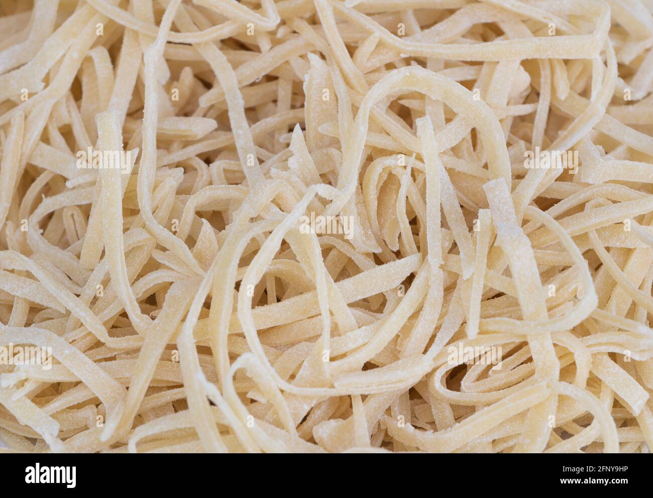 Frische hausgemachte ungekochte Pasta Textur Hintergrund. Rezepturkonzept Stockfoto