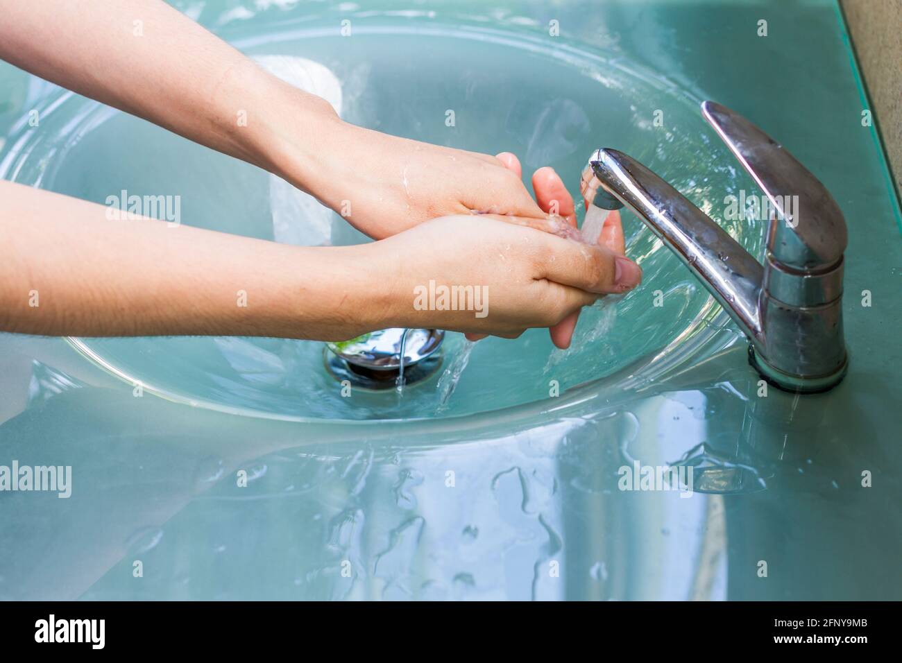 Hände waschen und den Wasserhahn aus der Tür drehen Stockfoto