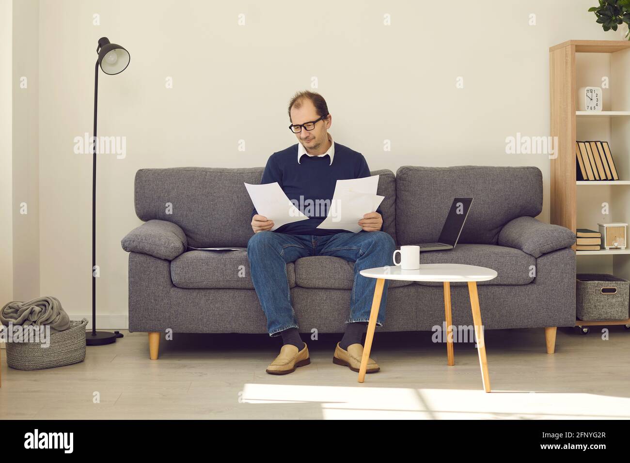 Senioren sitzen auf der Couch zu Hause beschäftigt mit Haushalt Oder Rentenpapiere Stockfoto