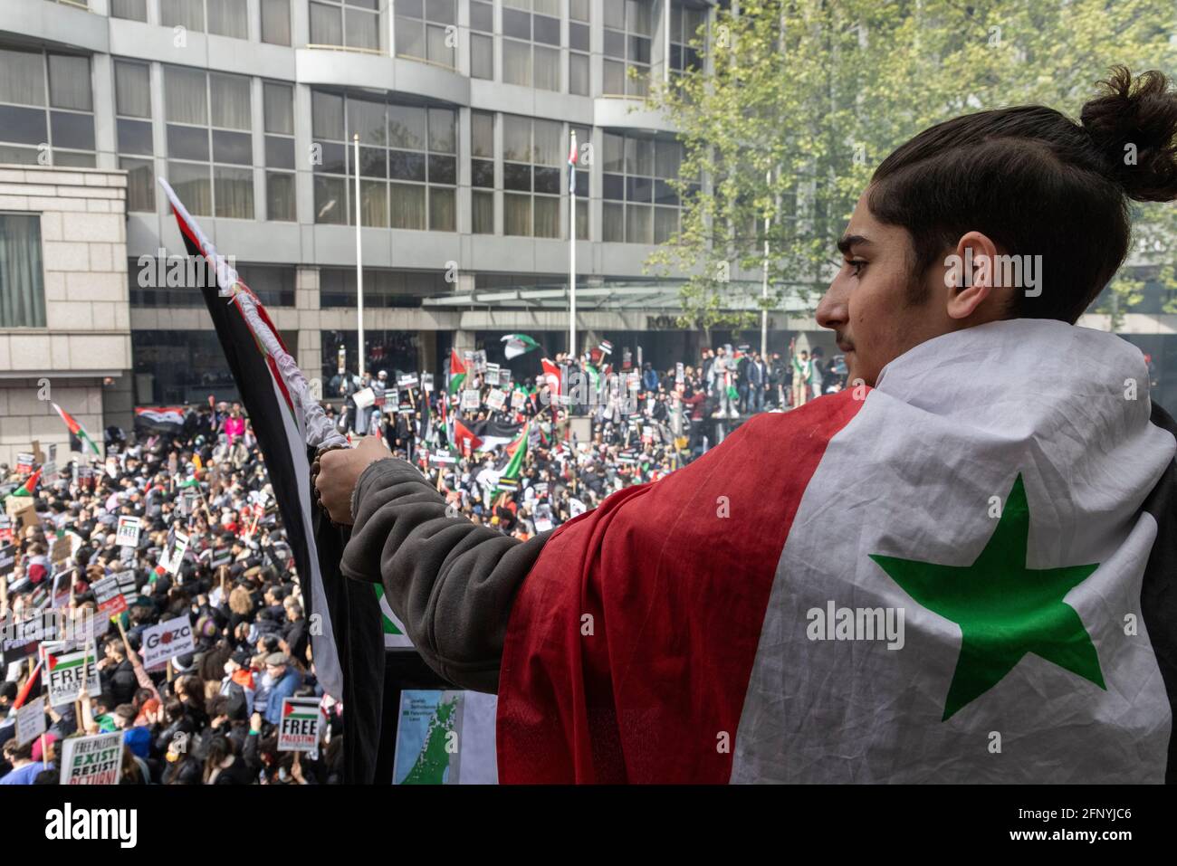 Protestler winkt Flagge über Menschenmenge, Solidaritätsprotest „Freies Palästina“, London, 15. Mai 2021 Stockfoto