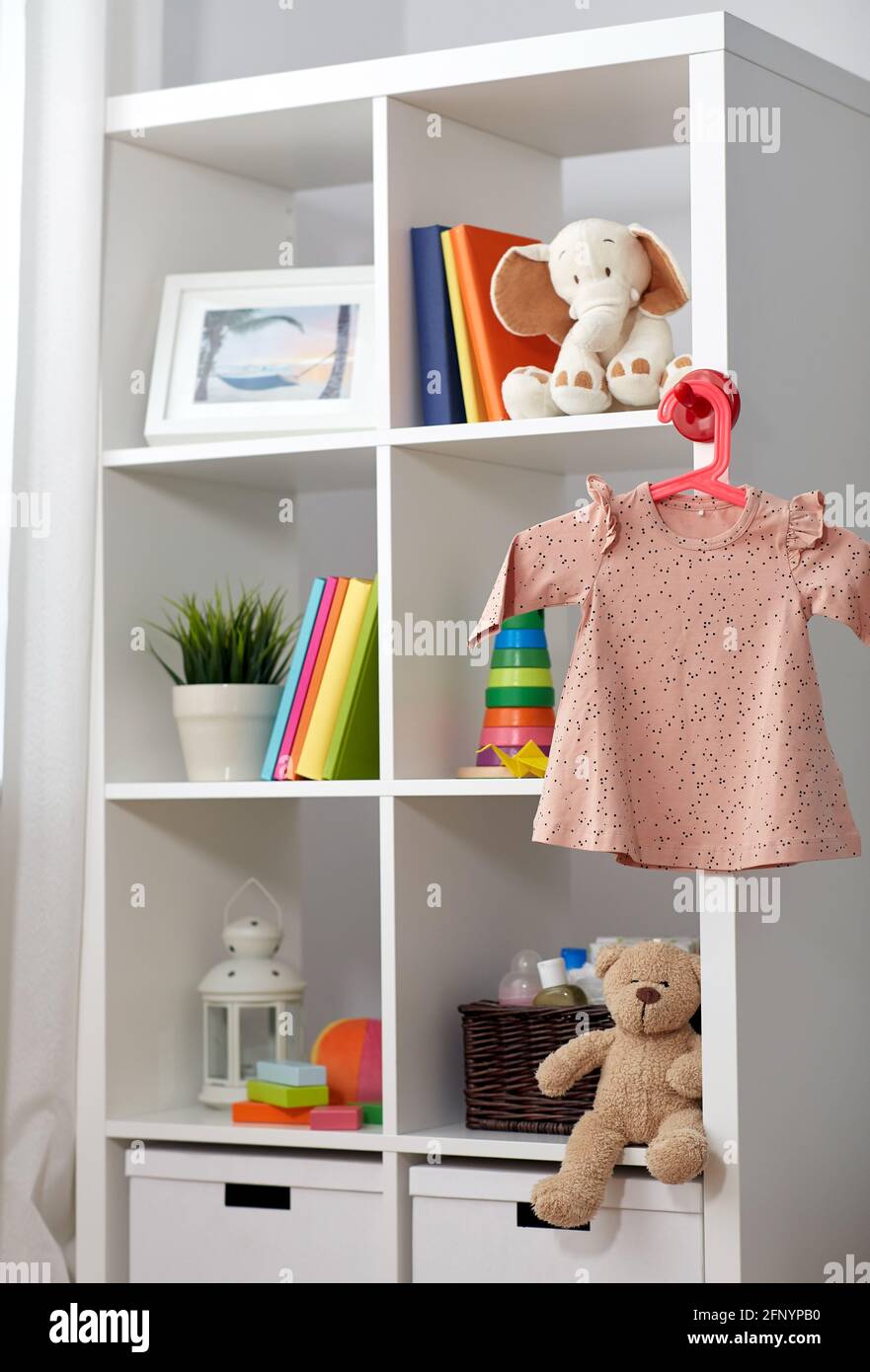 Kinderzimmer mit Bücherregal und Babykleid Stockfoto