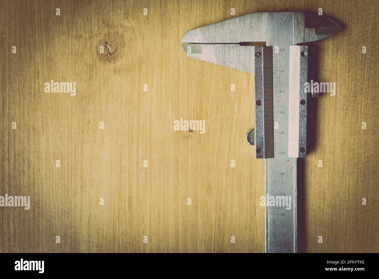 Nahaufnahme eines Messers mit Vernier auf einem Holzhintergrund. Stockfoto