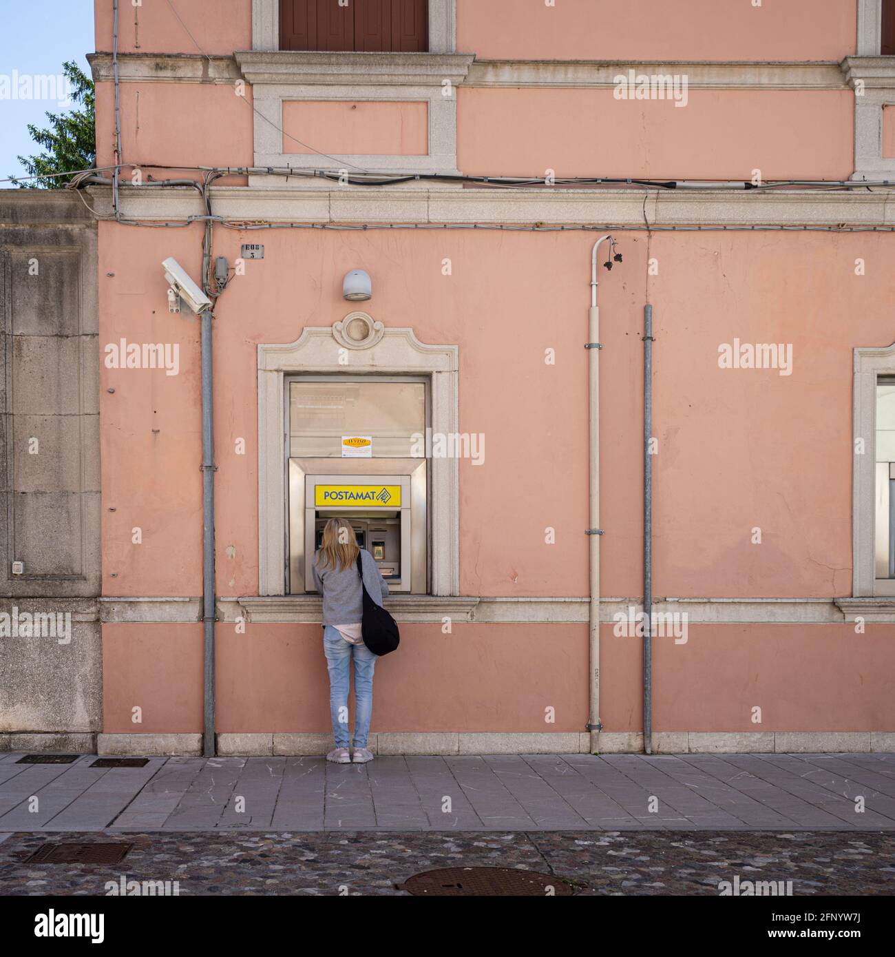 Palmanova, Italien. 18. Mai 2021. Eine Frau, die an einem Geldautomaten abheben wird Stockfoto