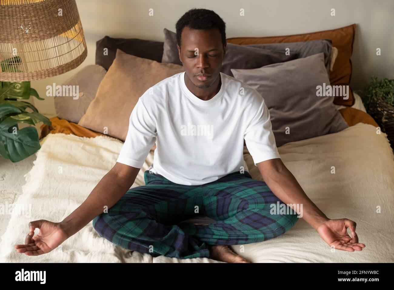 Junger afrikanischer Mann meditiert an seinem Schlafzimmer in der sitzend Morgen Stockfoto