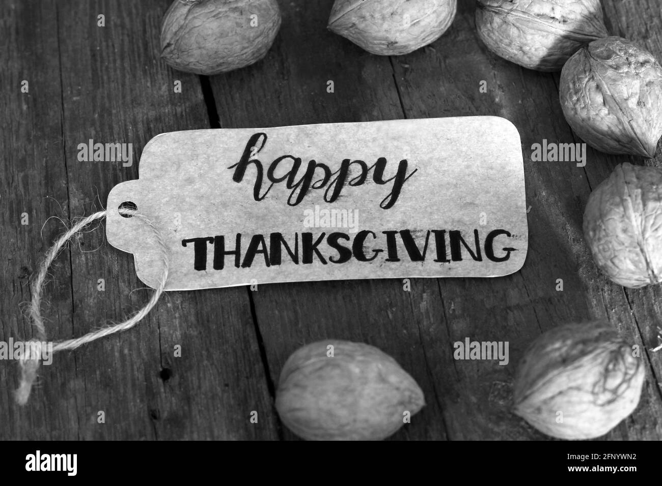 Die Inschrift 'Happy Thanksgiving' und Nüsse auf einem hölzernen Hintergrund Stockfoto