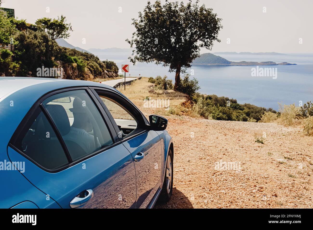 Blaues Auto hielt am Straßenrand in der Nähe des Meeres an sonnigen Tag Stockfoto