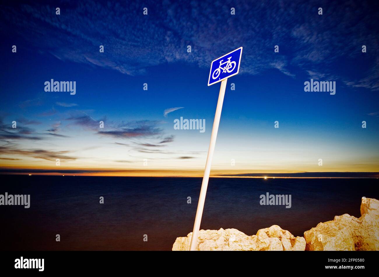 Lehnt über Radweg Zeichen gegen ein dunkles Meer und Abendhimmel Blackpool, England. Stockfoto